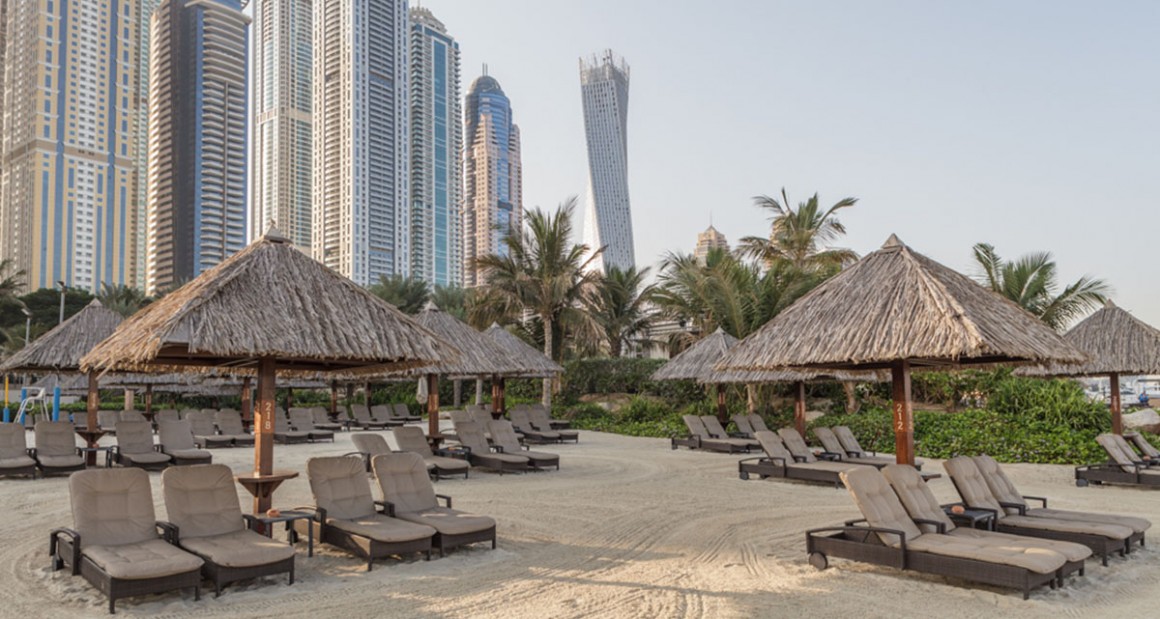 Thatched umbrellas and beach lounges. Photograph by Walter Shintani.