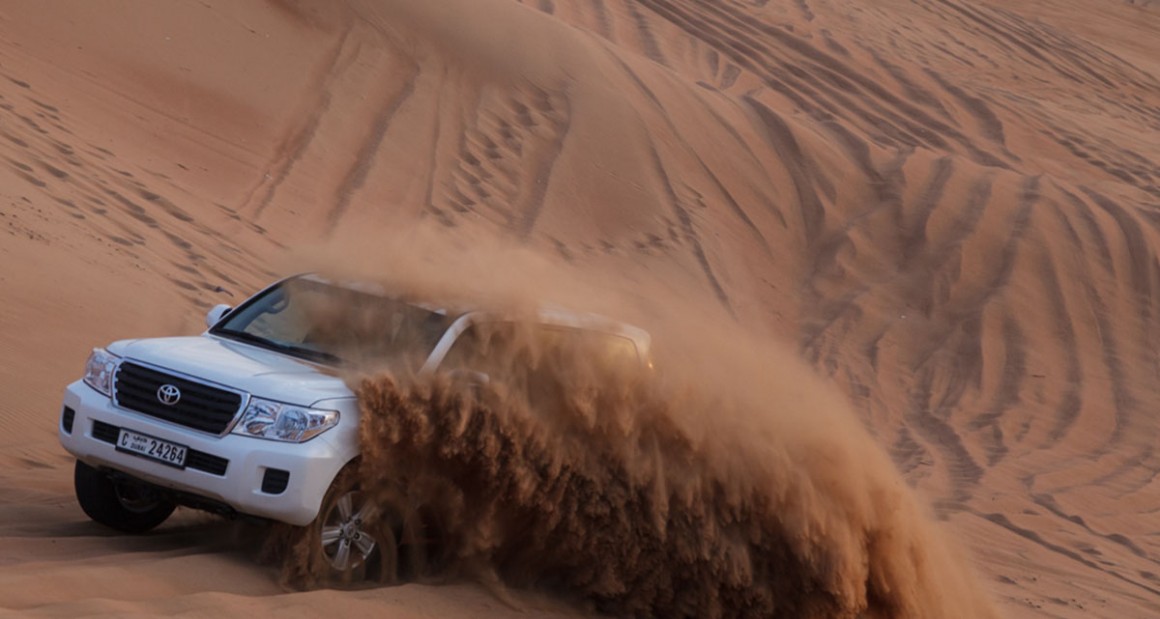 Sands fly while "dune bashing." Photograph by Walter Shintani.
